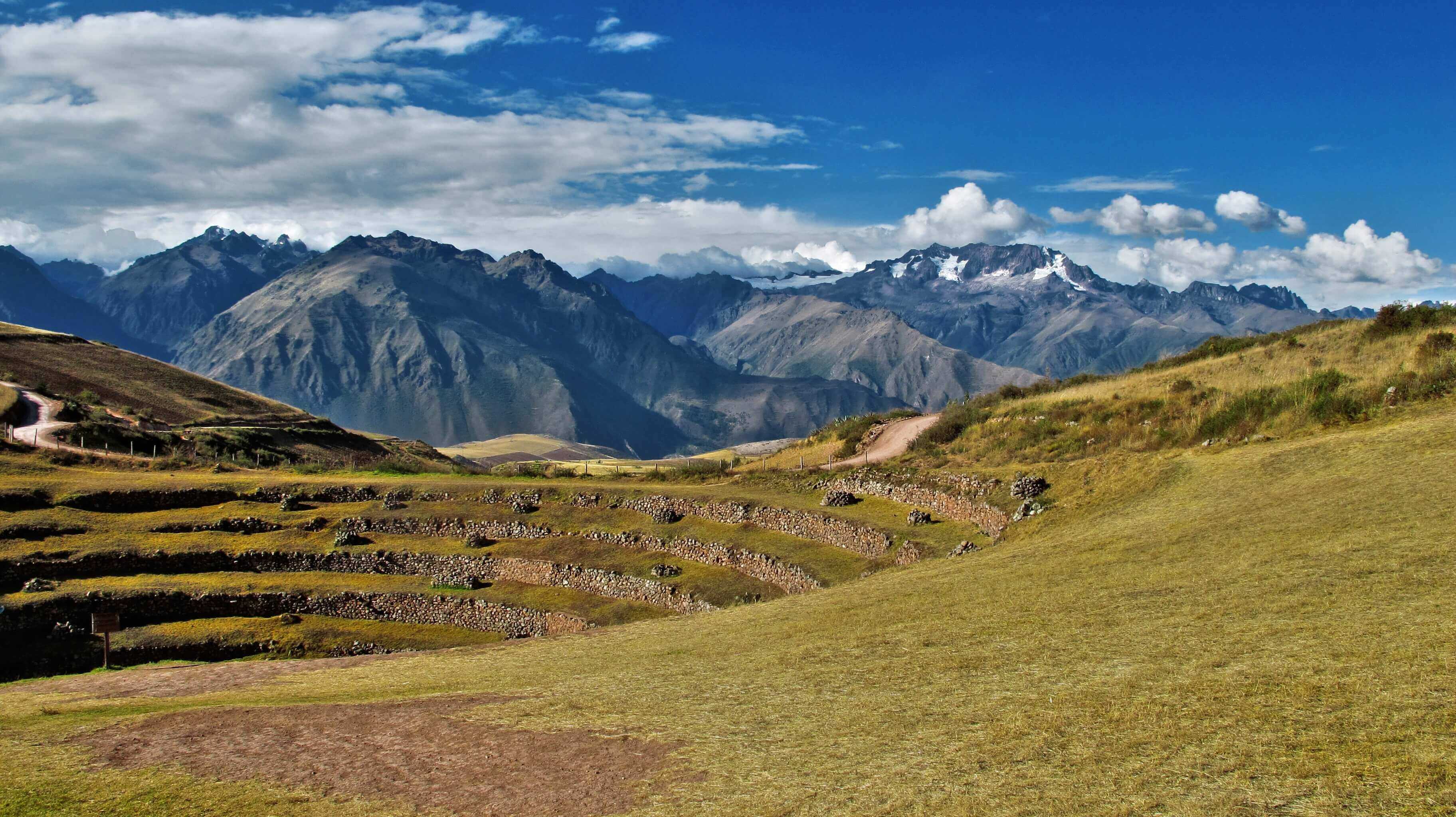 Ancient circular terraces of Moray unfold beneath snow-capped Andean peaks in the Sacred Valley. 
