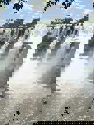 Panoramic view of Iguazu Falls surrounded by lush rainforest. 