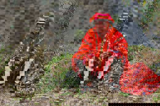 A local man in vibrant Andean dress plays a flute, embodying the spirit and culture of Peru's Sacred Valley. 
