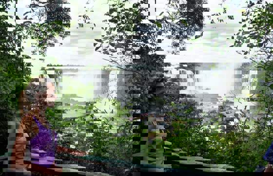 Viewpoint over Iguassu Falls in Brazil, framed by tropical rainforest and mist.