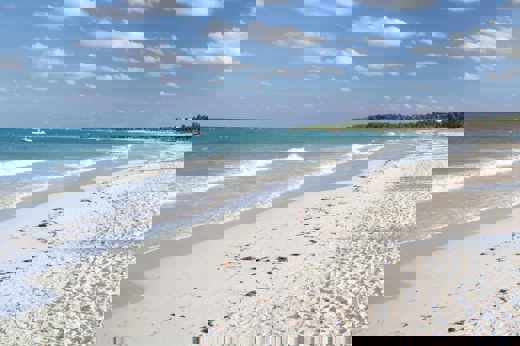 Beautiful white sand beach along the Yucatan coast in Mexico, with turquoise waters and tropical palm trees. 