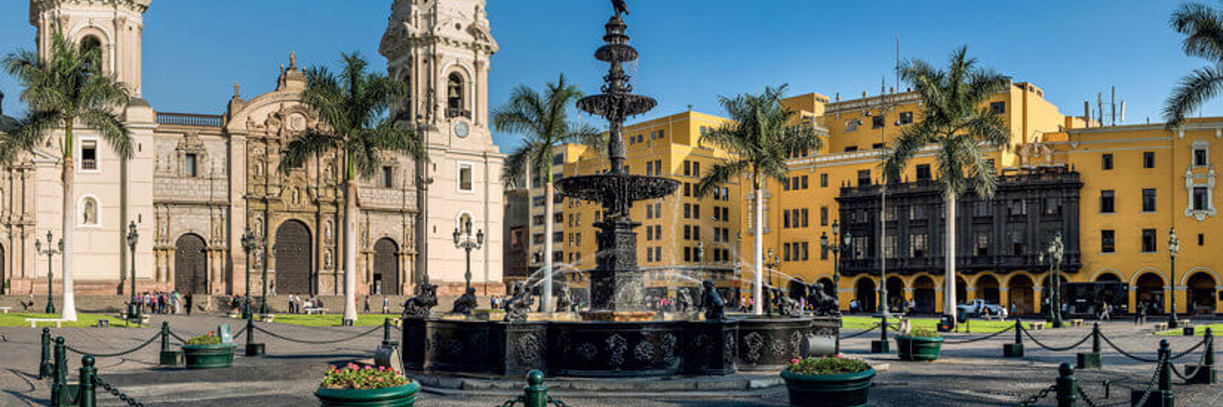 Historic Cathedral of Lima and Plaza de Armas with colonial architecture and palm trees. 